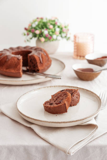 istock Chocolate cake with chocolate icing on white wooden table. Front view 2198843811