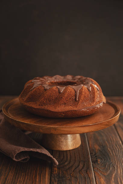 istock Chocolate cake with chocolate icing on dark wooden table. Low key. Front view 2198843846