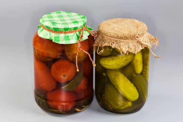 istock Canned tomatoes and cucumbers in two different sealed glass jars 2198844202