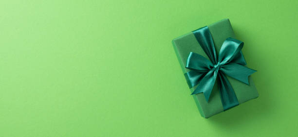 istock A beautifully wrapped green gift box with a matching ribbon lying against a solid green backdrop, conveying a sense of celebration, elegance, and festive spirit 2198847669