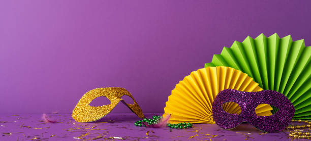 istock Mardi Gras side view themed accessories including glitter masks and festive decorations on purple background 2198847682