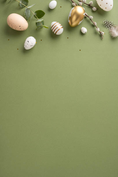 istock A vertical festive Easter arrangement featuring decorative eggs, greenery, and feathers on a green backdrop 2198847736