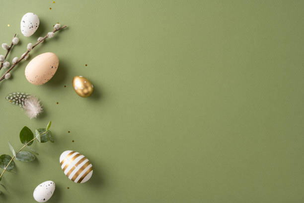 istock Stylish arrangement of Easter eggs with natural decorations and greenery on a green surface 2198847747