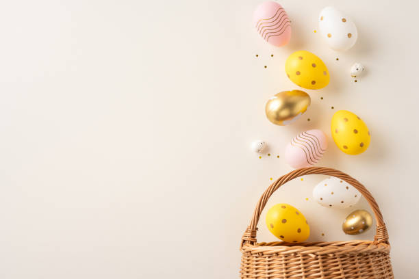 istock Easter-themed composition featuring a wicker basket and multicolored decorated eggs in a creative arrangement 2198847772