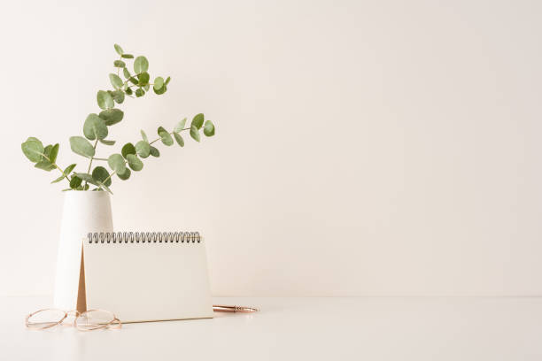 istock A neat and minimal workspace arrangement, showcasing a notebook, potted greenery, and glasses placed on a clean surface. Perfect for productivity, office themes, or creative inspirations 2198847773