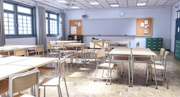 istock Empty classroom with wooden tables and chairs is waiting for students 2198849027