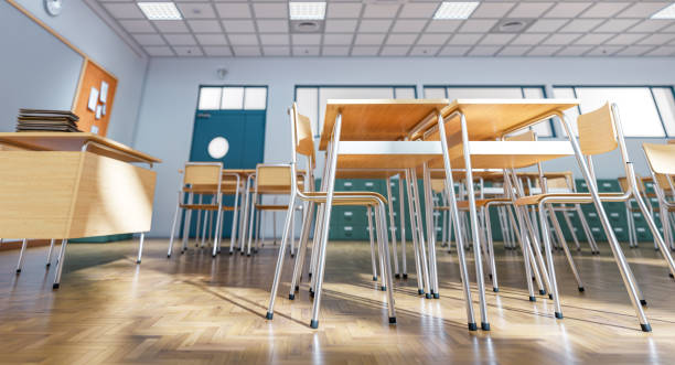 istock Empty classroom with wooden desks and chairs awaiting students 2198849039
