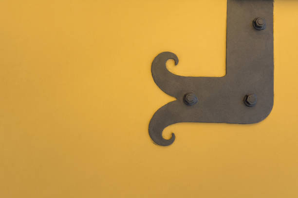 istock Forged vintage metal hinges on a yellow wall.copy space. 2198851369