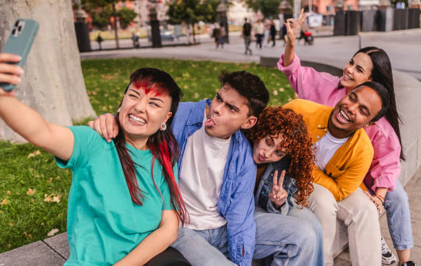 istock Group of young adults taking a selfie and making funny faces in a park 2198852869