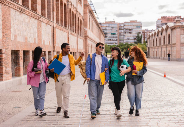 istock Diverse college students walking and talking together on campus 2198852889