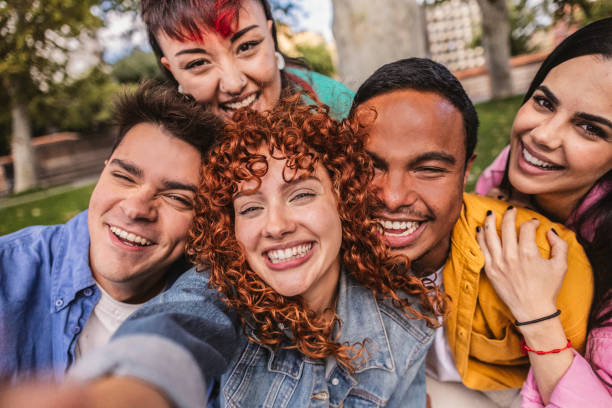 istock Group of happy young adults taking a selfie in a park 2198852900