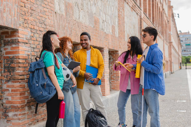 istock University students talking and smiling outdoors near brick wall 2198852937