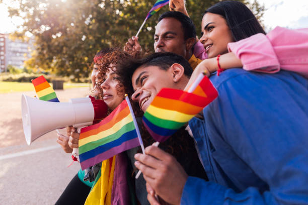 istock Young activists protesting for lgbtq rights waving rainbow flags 2198853063