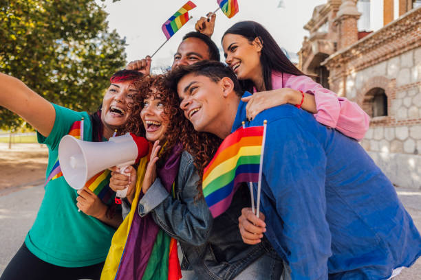 istock Young activists taking selfie at lgbtq+ pride parade with rainbow flags and megaphone 2198853104