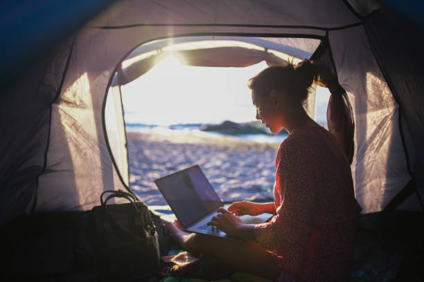 istock Sunrise serenity: woman working remotely from a beach tent. 2198856032