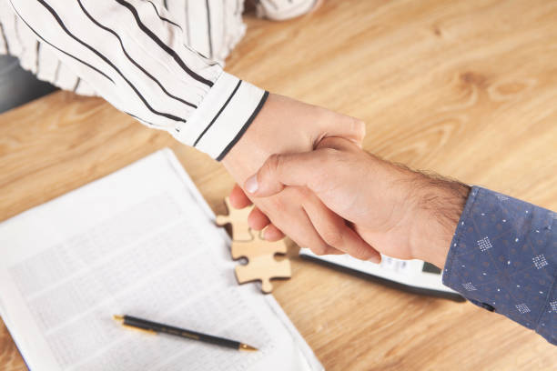 istock man and woman shake hands at the desktop 2198860771