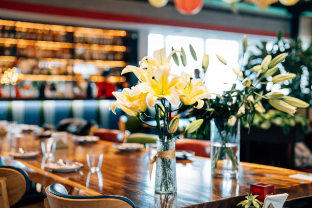 Empty restaurant interior with the white lilies in the vase the wooden table.