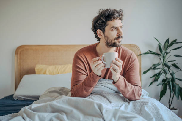 istock Relaxed Young handsome middle eastern man Enjoying Morning Coffee in Bed. 2198868820