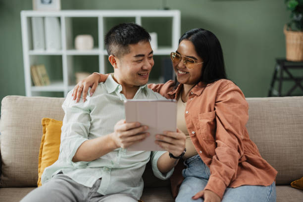 istock Couple Engaged with Tablet on Casual Sofa Setting 2198869339