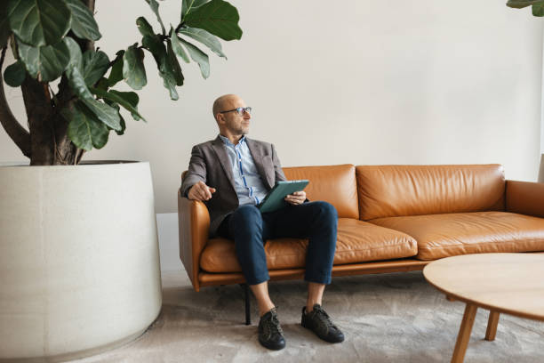 istock Contemplative man with a tablet in a modern space 2198870291