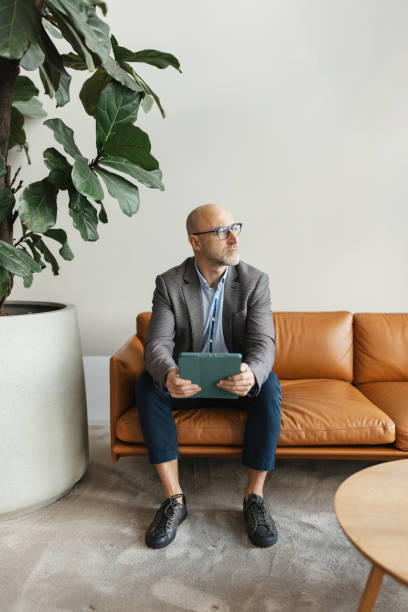 istock Smiling man enjoying tech in a cozy lounge 2198870356