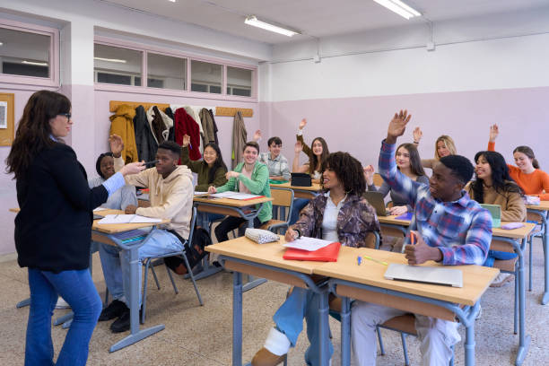 istock High school students raising hands in classroom to answer teacher question 2198873377