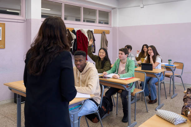 istock High school students raising hands in classroom during lesson 2198873434