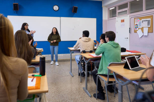 istock High school students applauding classmate after presentation in classroom 2198873490