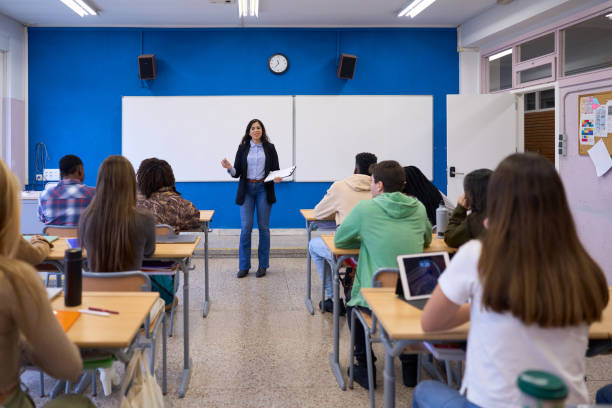 istock High school teacher explaining lesson to students in classroom 2198873652