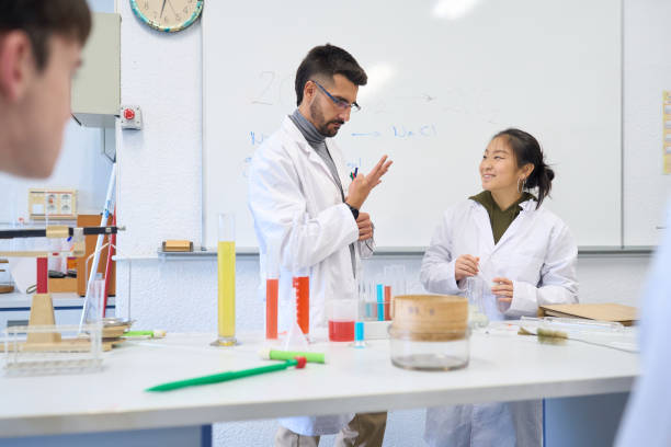 istock High school chemistry teacher explaining experiment to student 2198875239