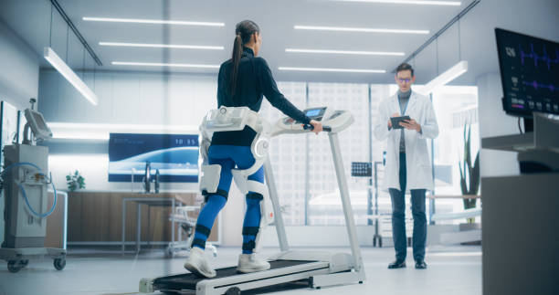 istock Advanced Physical Rehabilitation in a Futuristic Medical Lab Using an Exosuit on a Treadmill, Monitored by a Doctor. Advanced Technology Enhances Recovery Possibilities Through Innovative Research 2198877329