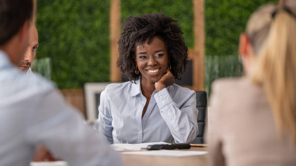 istock Confident woman presenting ideas in team setting, hand gesture conveying assurance. 2198882091