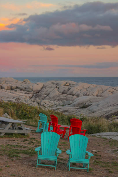 Adirondack chairs at sunset at Peggy's Cove, a famous fishing town located in the maritime province of Nova Scotia, on Canada's East Coast. Nowadays Peggy’s Cove is considered a major tourist attraction in the Maritimes.