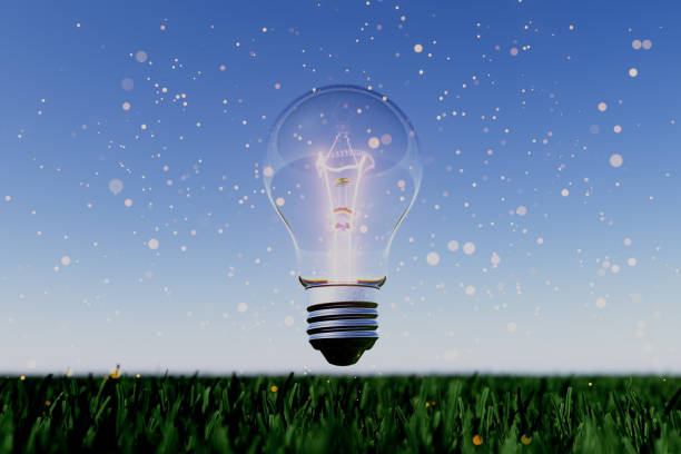 A light bulb is floating in the air above a field of grass. The light bulb is glowing brightly, illuminating the grass and creating a sense of warmth and energy. The scene evokes a feeling of hope