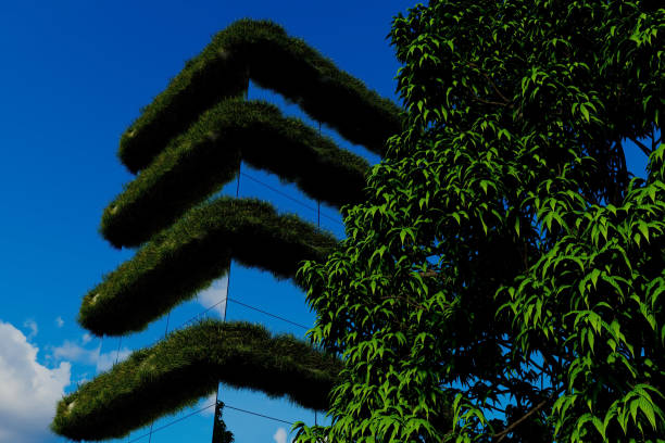 A tall building with a green roof and a tree next to it. The tree is green and has leaves