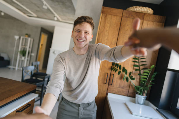 istock Young man shaking hands with someone in the kitchen 2198884858