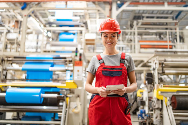 istock Industrial engineer analyzing data on tablet surrounded by large machinery in factory setting. 2198886289