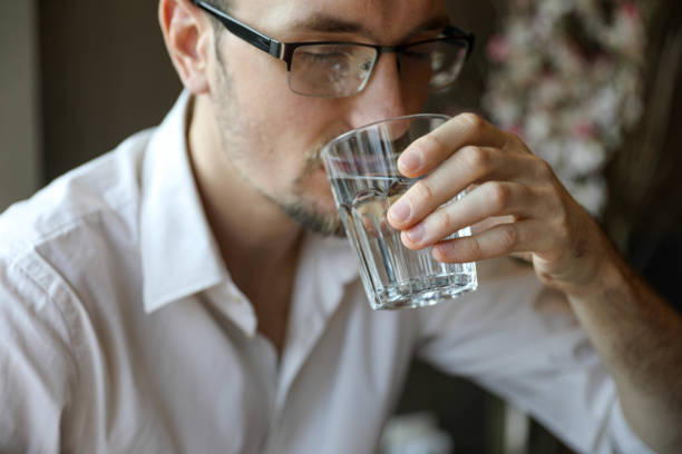 istock Handsome young man drinking water from a water glass 2198890612