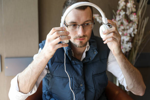 A young man putting on headphones