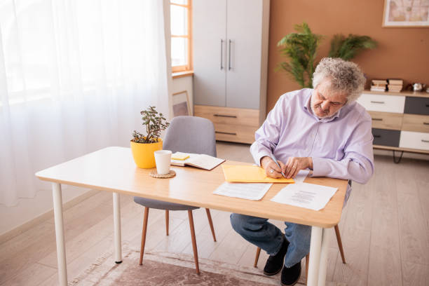 istock Senior man working with paperwork at home 2198891449