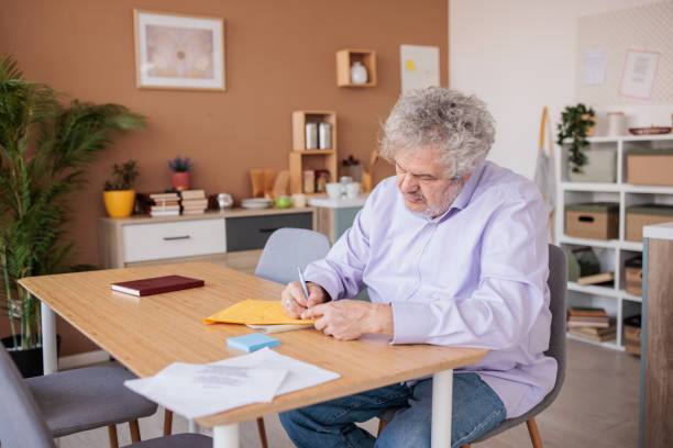 istock Senior man working with paperwork at home 2198892527