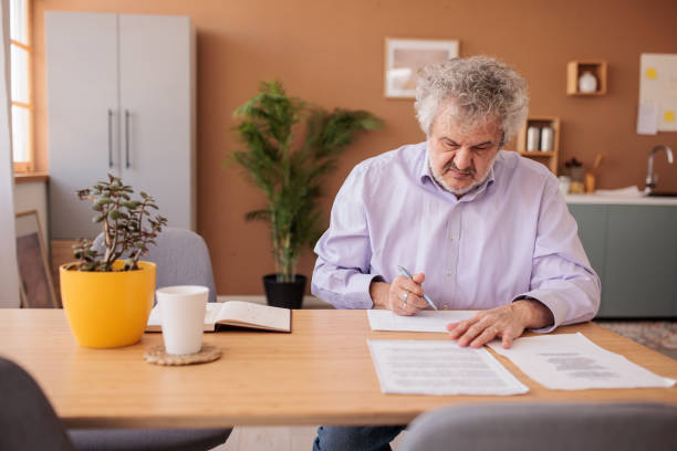 istock Senior man working with paperwork at home 2198892648
