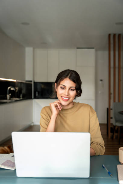istock Middle eastern or latin freelance businesswoman entrepreneur using computer AI app for online remote business work. Young smiling IT specialist woman working on laptop pc at home remotely. Vertical 2198894271