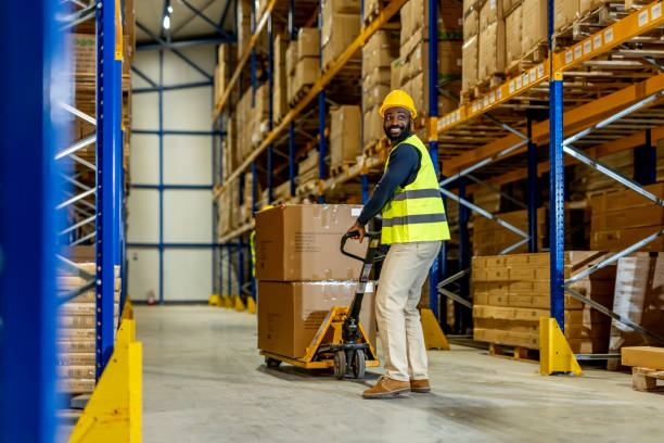 istock Warehouse Worker Operating Pallet Jack in Industrial Storage Area 2198896161