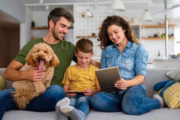 istock Parents with kid having fun online with application watching video cartoon or playing game on tablet 2198897203