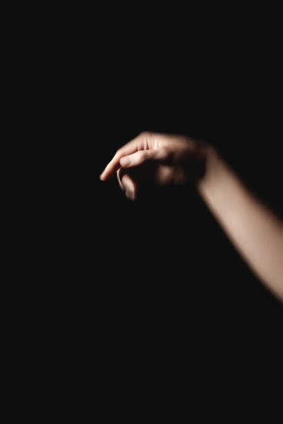 istock Dark minimalist background highlighting slender hand reaching outward, expressing elegant mystery with understated sophistication book cover copy space 2198897445