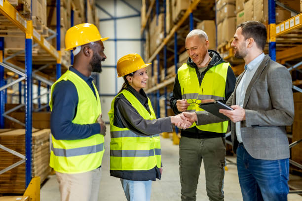 istock Team Shaking Hands in Warehouse Environment with Shelves in Background 2198897595