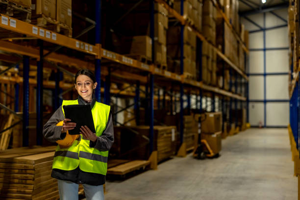 istock Female Warehouse Worker Managing Inventory with a Digital Tablet in a Distribution Center 2198899457
