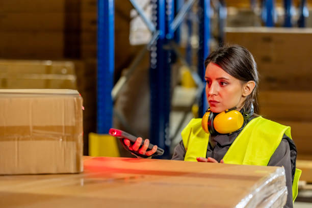 istock Factory Worker Scanning Package in Distribution Center With Scanner Device 2198899516