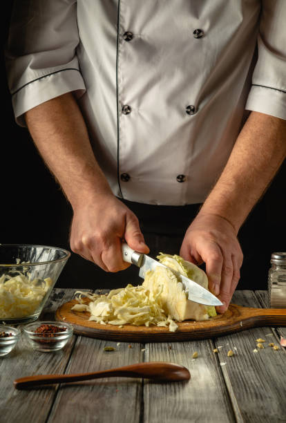 istock In a cozy kitchen, a chef expertly chops fresh cabbage, showcasing culinary skills. Surrounded by spices and utensils, the atmosphere is warm and inviting, perfect for cooking enthusiasts 2198899964